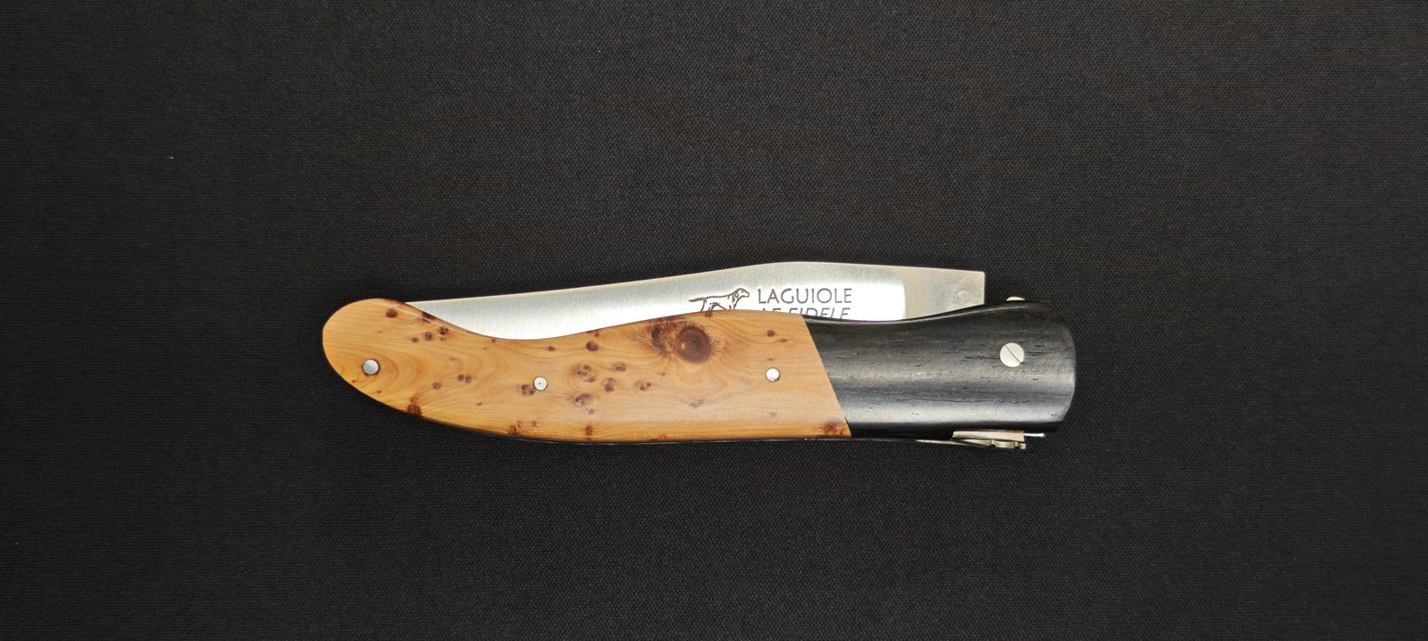 Couteau Laguiole fermé mettant en valeur les essences d'ébène et de genévrier