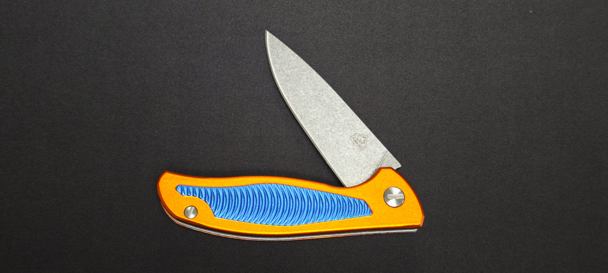 Couteau pliant Puma Tec 306613 avec manche en aluminium orange et bleu.