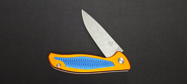 Couteau pliant Puma Tec 306613 avec manche en aluminium orange et bleu.